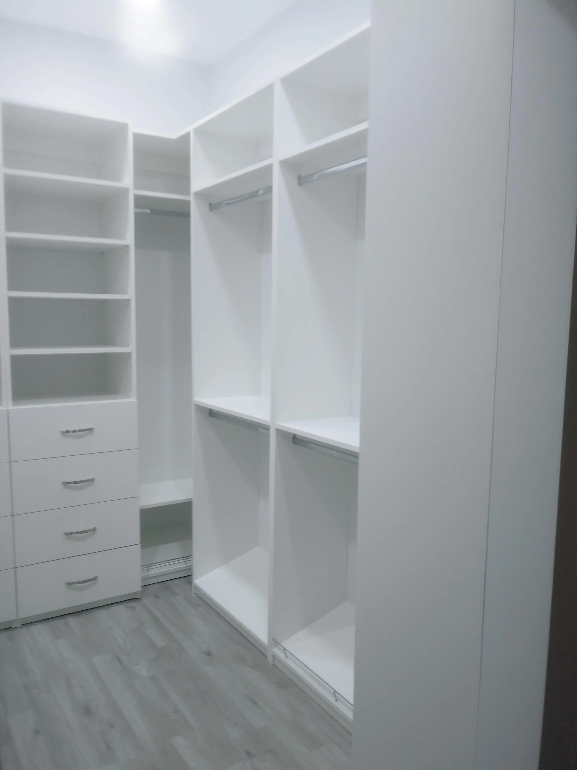 Custom white closet with shelving and hanging space