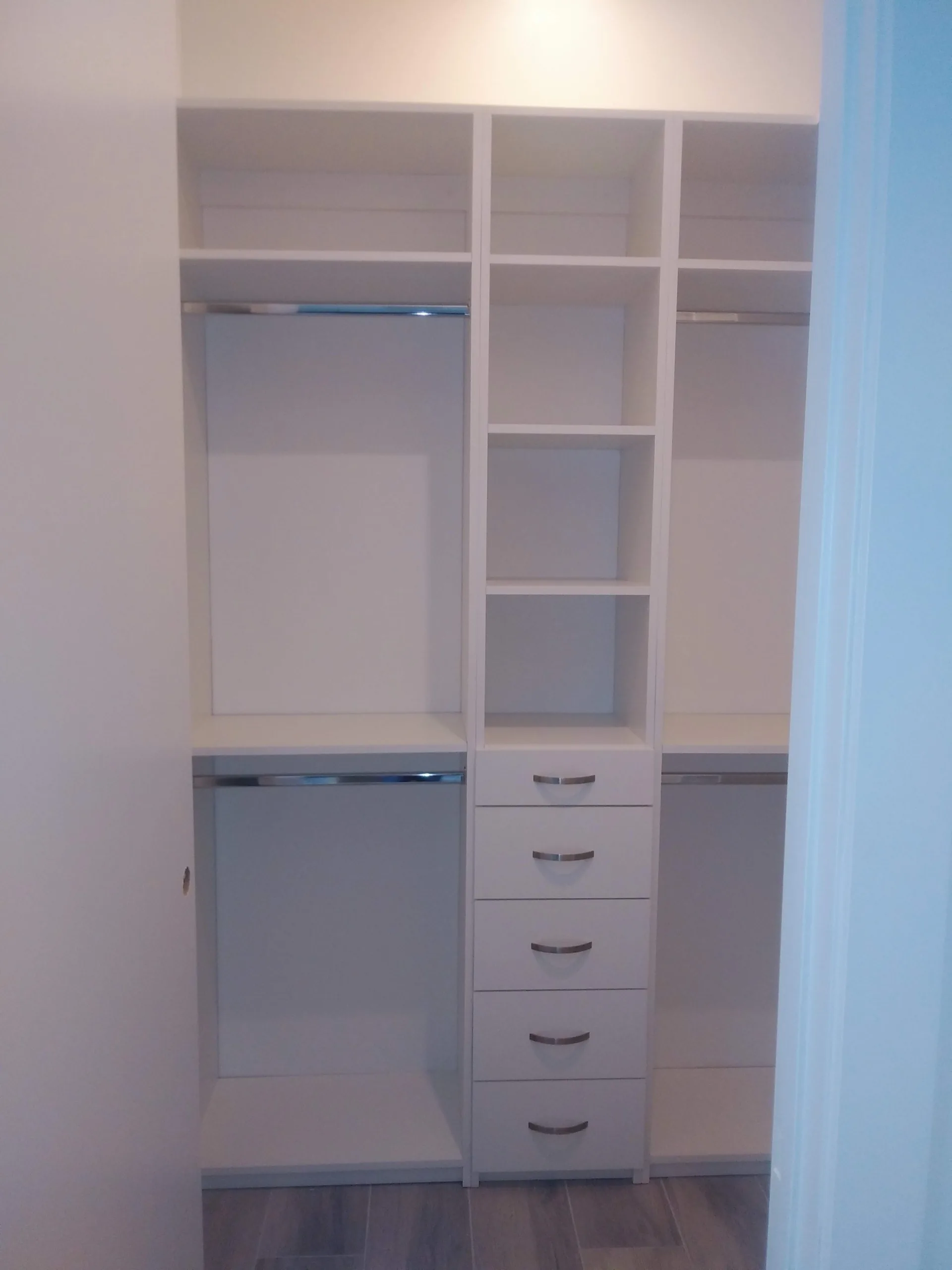 Custom white closet with shelving and hanging space