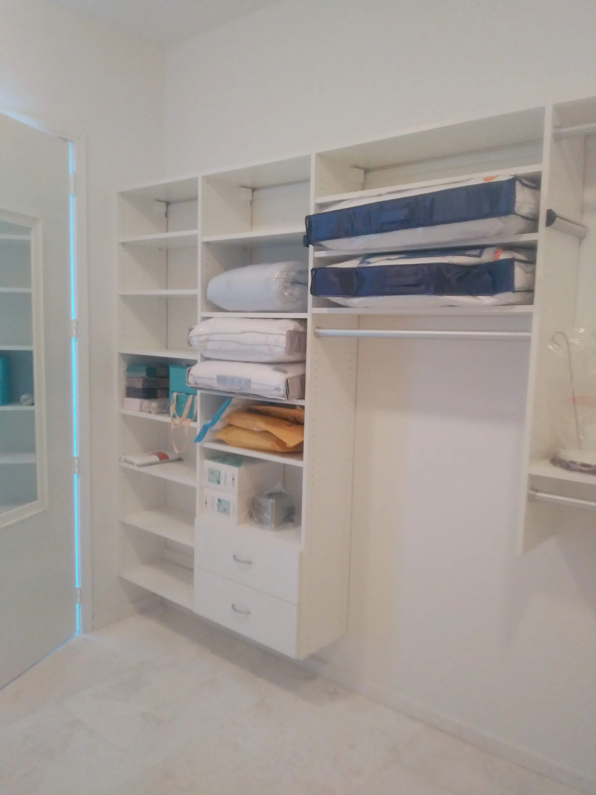 Custom white closet with shelving and hanging space