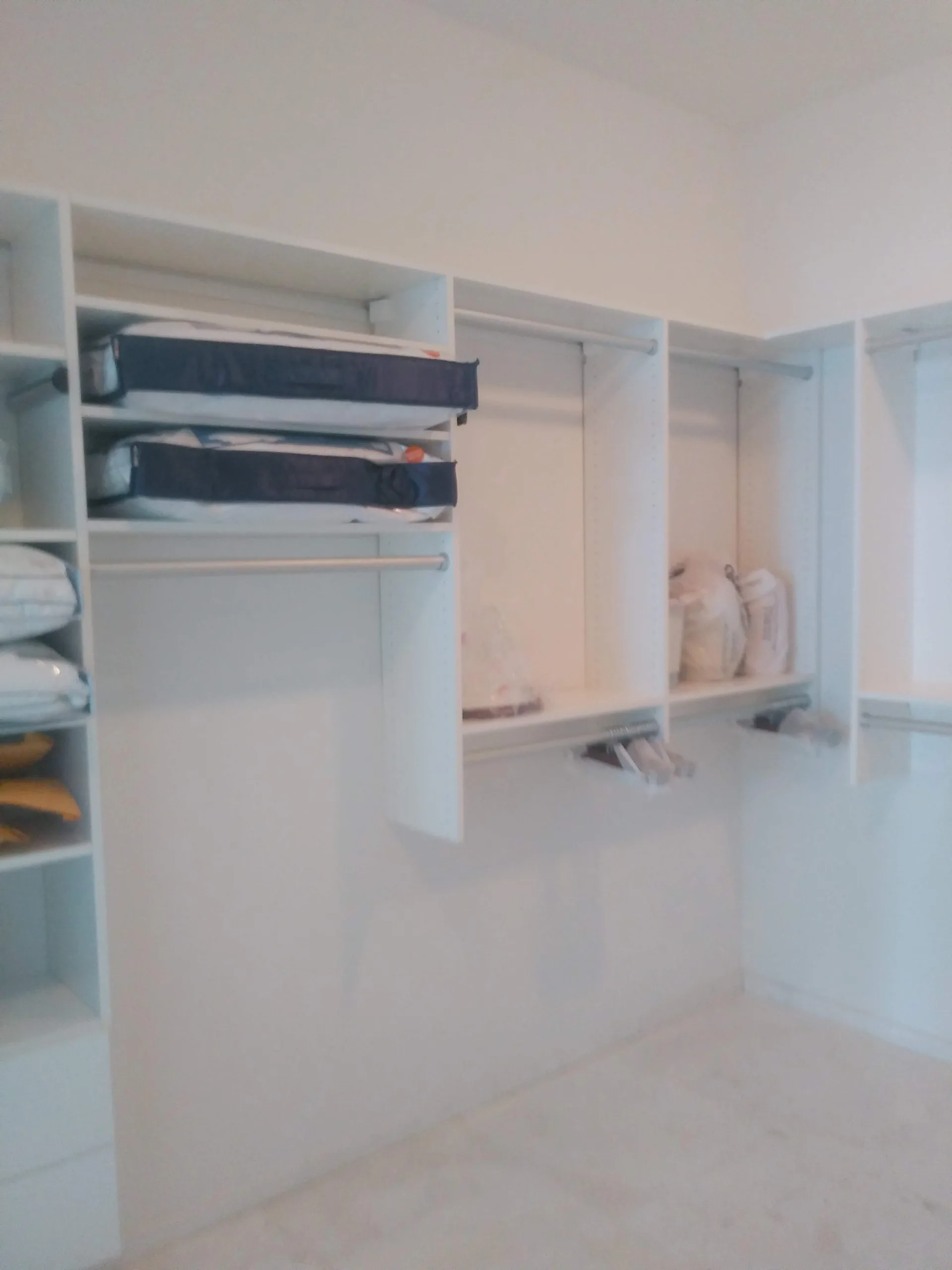 Custom white closet with shelving and hanging space