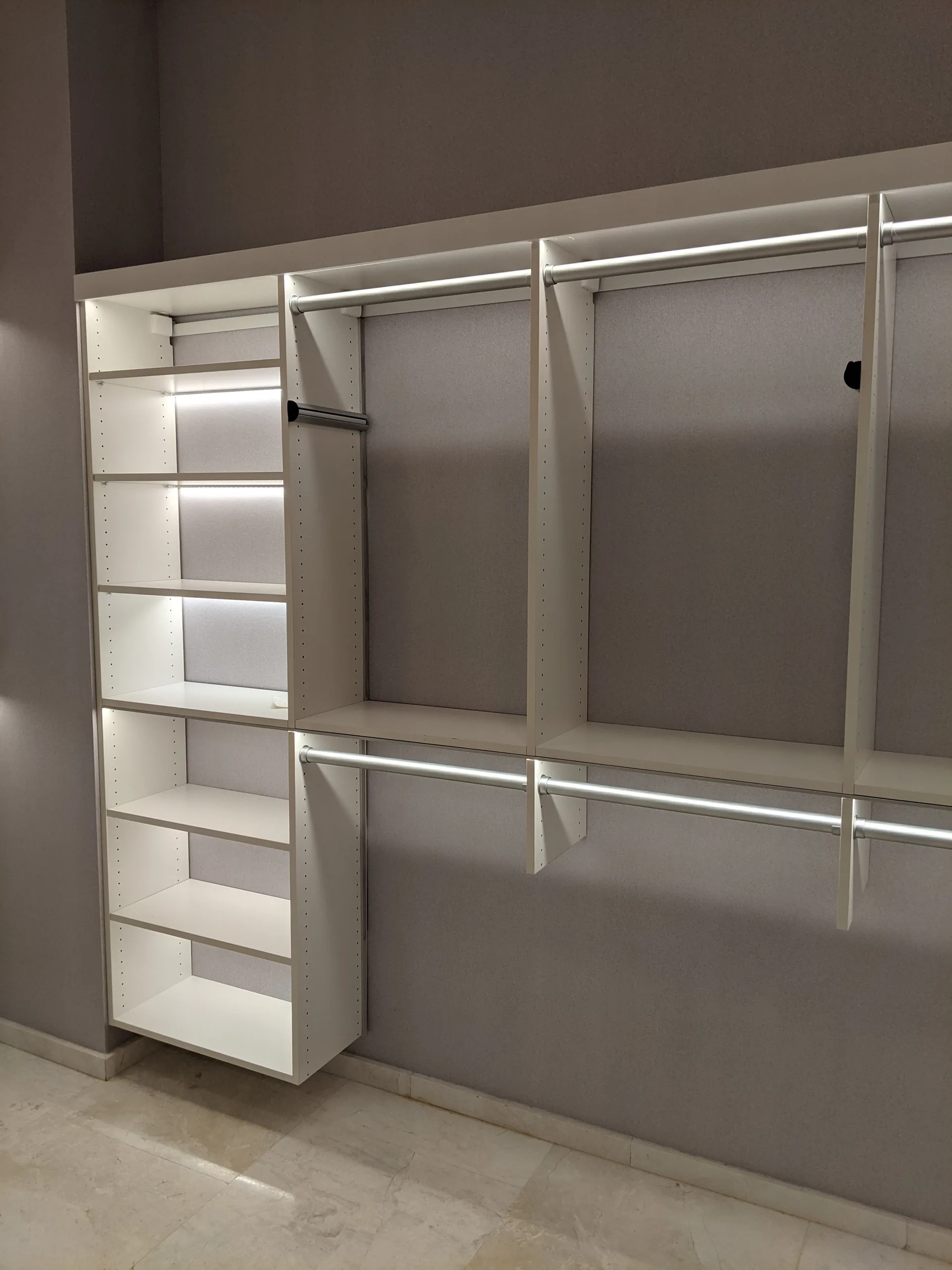 White closet with illuminated shelving