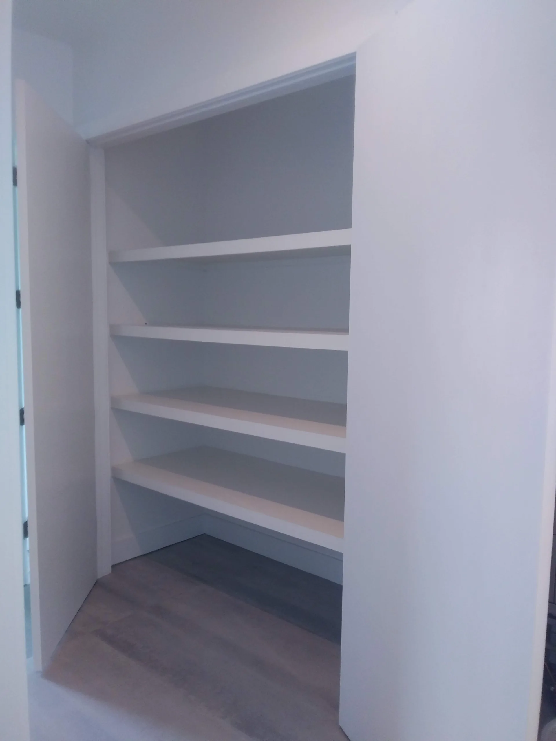 Custom white closet with shelving and hanging space